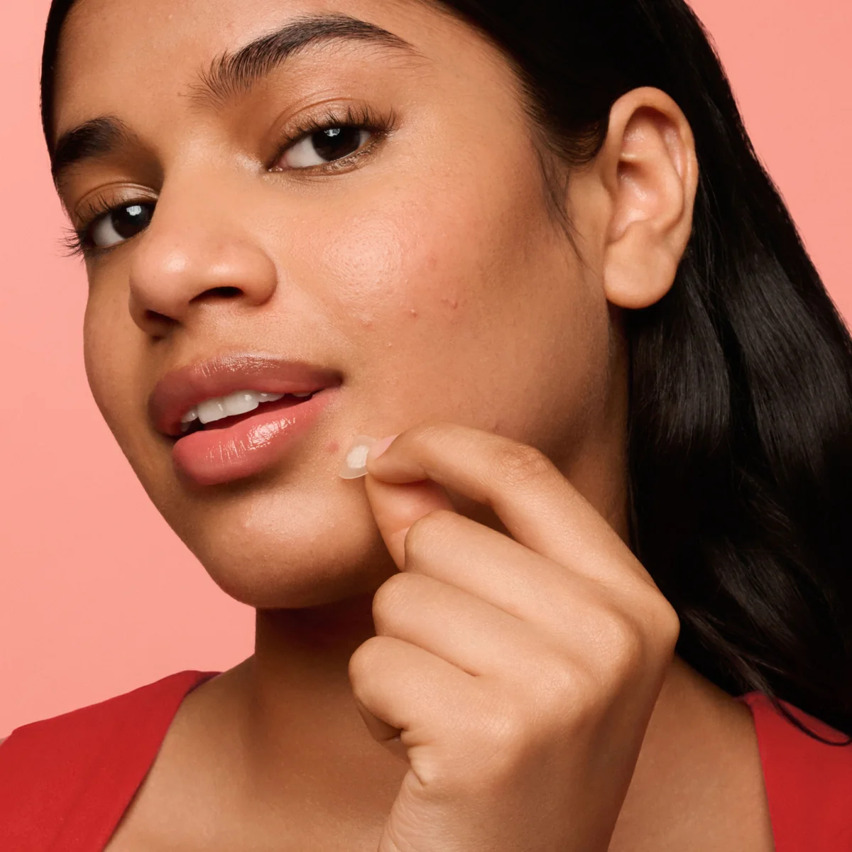 Person applying a Mighty Patch acne patch
